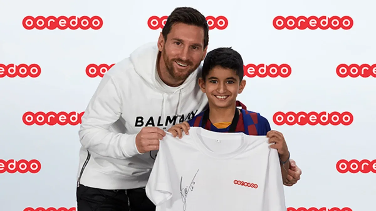 Messi with a fan at an Ooredoo Promotion event - World Sports Ambassadors Advertising